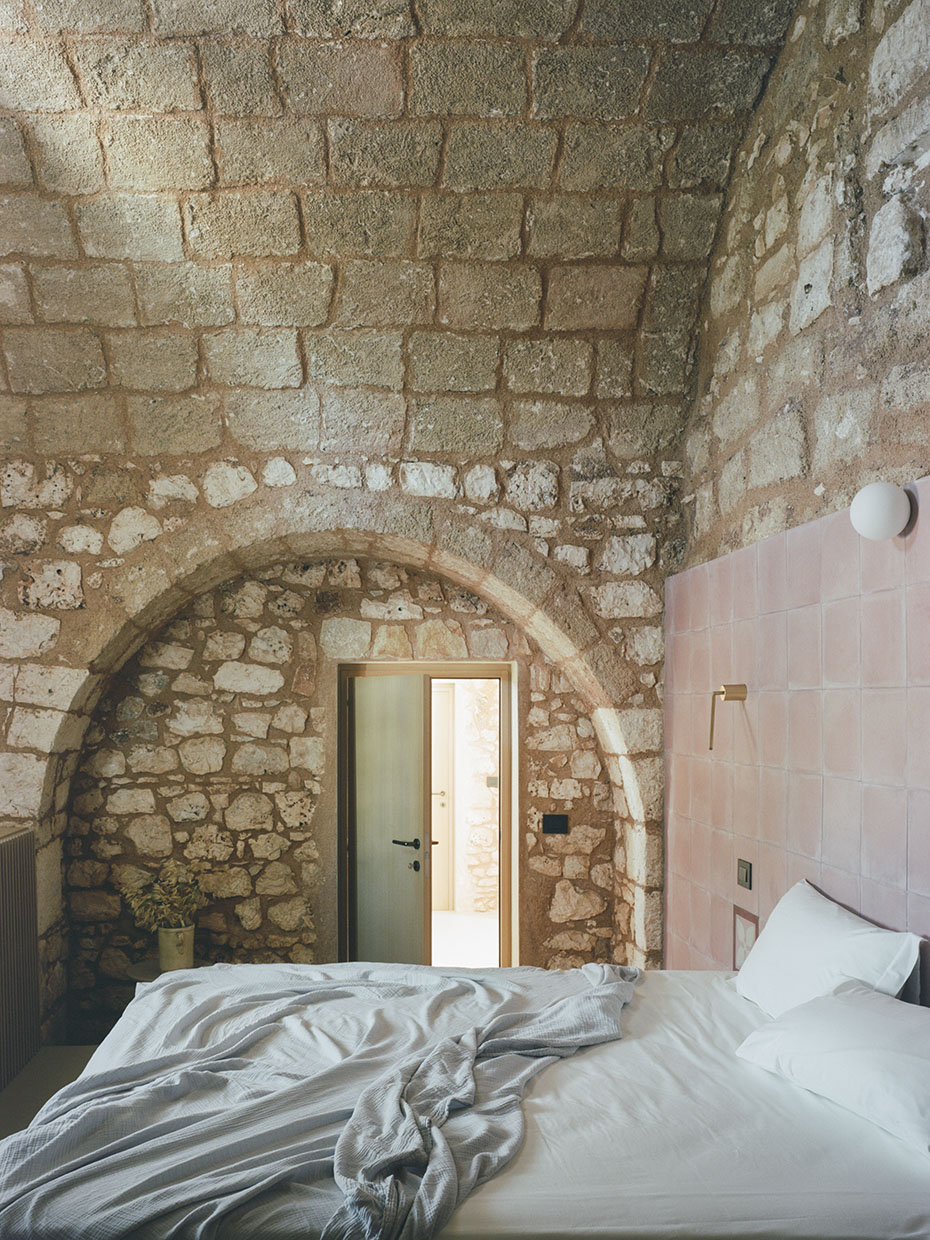 Blick in ein Schlafzimmer mit gemauerten Wänden aus Stein. Valari, Masseria Belvedere, Carovigno, Foto: ©Lorenzo Zandri