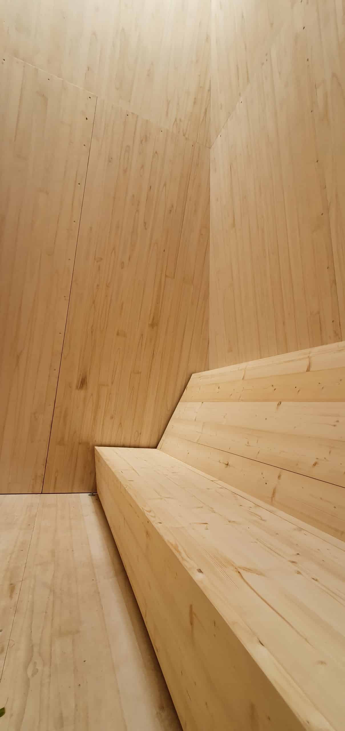 Eine lange, hölzerne Bank in einem Raum mit Wänden und Boden ebenfalls aus Holz. Documenta fifteen, Reflecting Point 7 am Hallenbad Ost: KIRI Project, Foto: