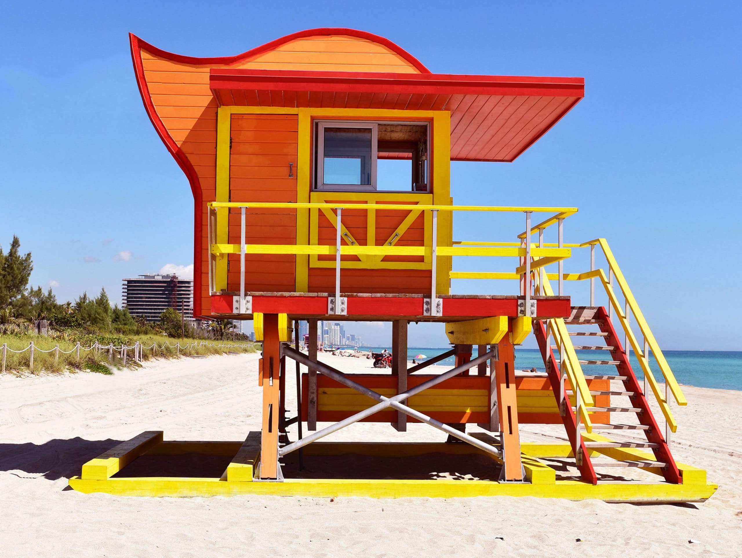 Ein orange-gelb-rotes Wasserwachthäuschen am Strand mit geschwungener Dachform. Miami Beach, Lifeguard Tower, William Lane, Foto: Archiv Architekten