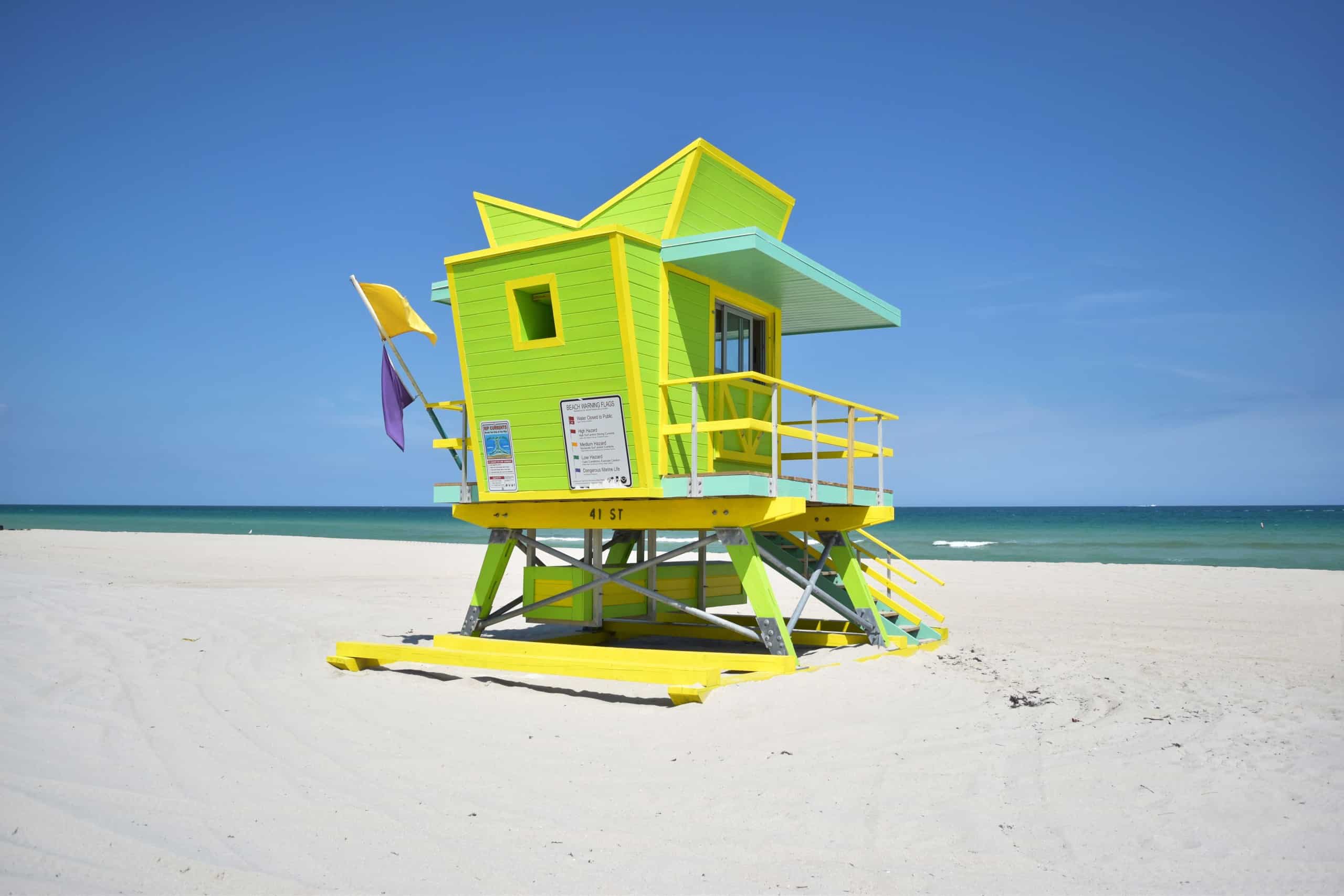 Blick von hinten auf ein hölzernes Wachhäuschen am Strand in Gründ und Gelb. Miami Beach, Lifeguard Tower, William Lane, Foto: Archiv Architekten