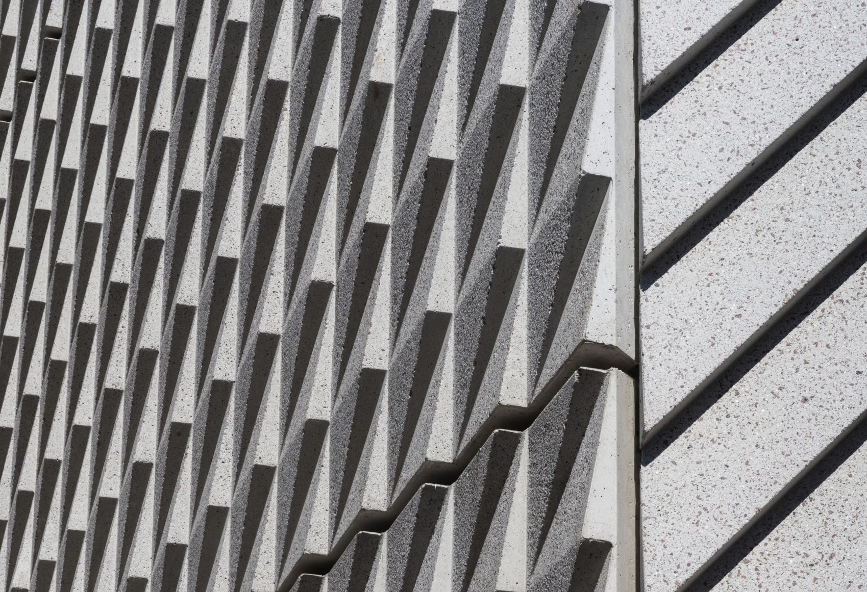 Die Fassade wirkt durch detailreiche Betonplatten passend zu den Schindelreliefs der Nachbarschaft. Foto: © Floto + Warner